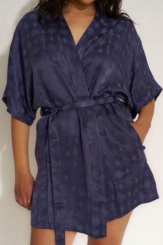Woman wearing a short navy blue robe from Be Idle.