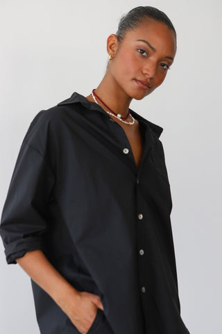 Woman wearing black cotton button up shirt