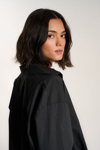 Woman wearing black cotton button up shirt
