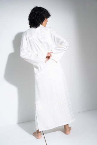 Woman wearing long white robe.