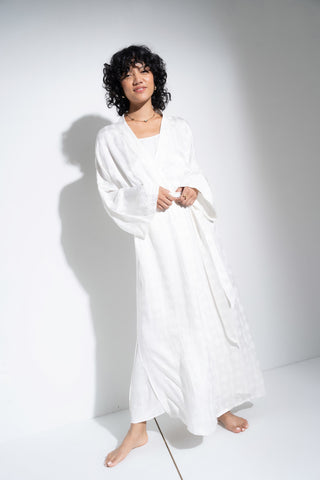 Woman wearing long white robe.