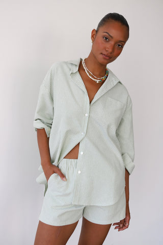 Woman wearing green and white pinstripe lounge shorts