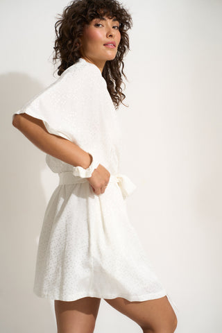 Woman wearing short white robe with matching scrunchie