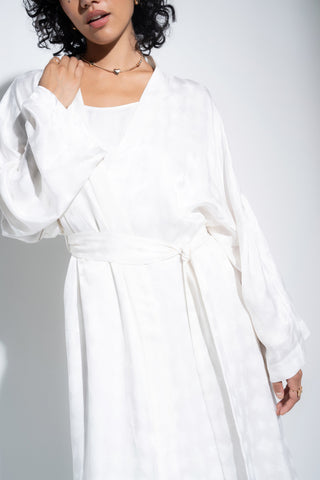Woman wearing long white robe.