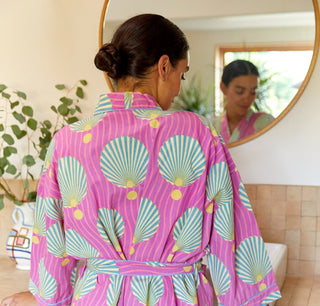 Woman wearing lightweight pink robe with seashell pattern