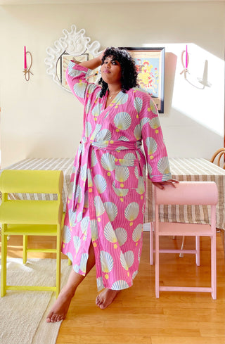 Woman in a pink robe with shell pattern.