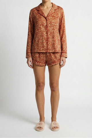 Woman wearing cozy long sleeve and matching short red leopard PJs