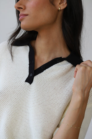 Woman wearing oversized crochet shirt in white with black neck detail