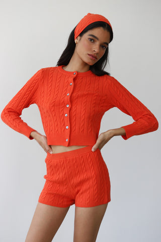 Woman wearing soft knit lounge shorts for women styled as a matching set in red poppy color