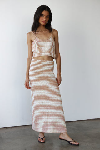 Woman wearing a beige and white striped knit tank top with matching skirt
