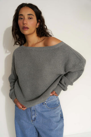 Woman wearing a gray off-shoulder sweater