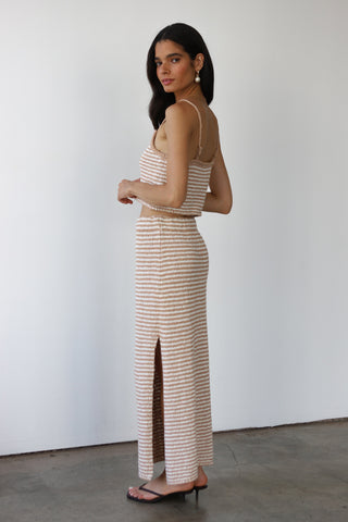 Woman wearing a beige and white striped cotton knit maxi skirt with matching tank
