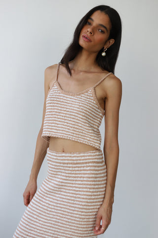 Woman wearing a beige and white striped knit tank top with matching skirt