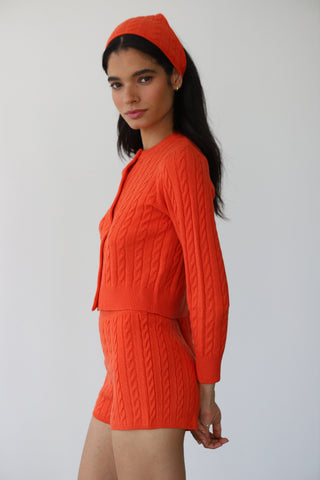 Woman wearing red cable-knit shorts paired with a matching loungwear cardigan