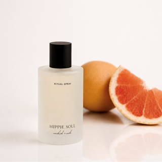 Bottle of 'Hippie Soul' ritual spray with a grapefruit on a light background