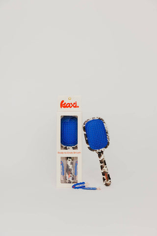 Cow print hairbrush with blue accent, matching clips in gift box
