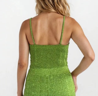 Back view of a woman wearing a green knit crop tank. White/grey background.