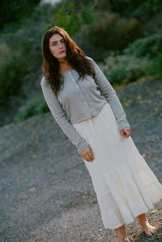 Woman wearing heather gray cotton ribbed cardigan with cropped fit and pearl front buttons