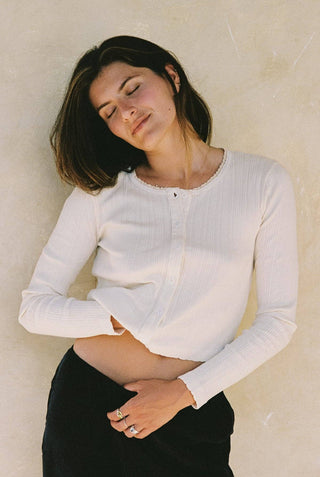 Woman wearing LA Relaxed pointelle cardigan with pearl buttons shown in natural color