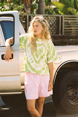 Woman wearing green and white tie-dyed relaxed fit t-shirt with fun heart pattern