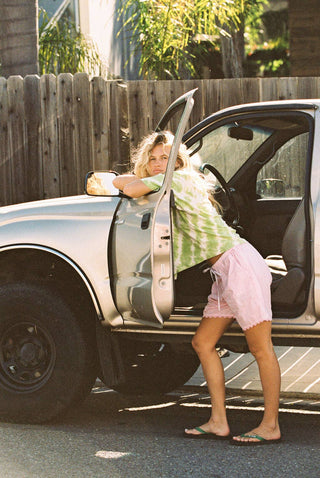 Woman wearing green and white tie-dye short sleeve tee with pink poplin shorts