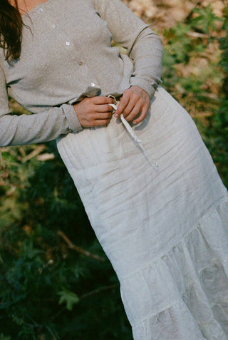 Woman wearing heather gray cotton ribbed cardigan with cropped fit and pearl front buttons