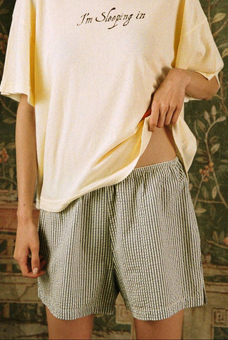 Woman wearing yellow and green striped cotton sleep shorts