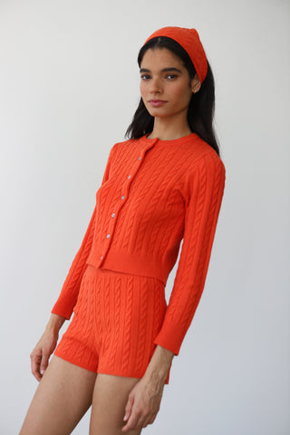 Woman wearing Callahan Knitwear red short and matching cardigan set