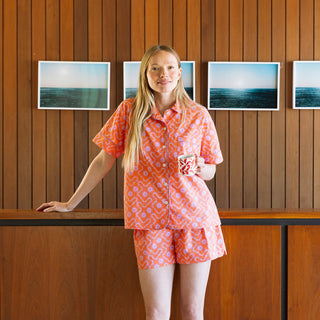 Matching pajama set for women in orange sherbet tones with button top and elastic waist shorts