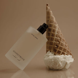 Product labeled 'Moonstruck Ritual Spray' next to a waffle cone with ice cream on a beige background