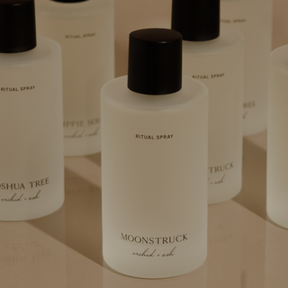 Bottles of 'Moonstruck' ritual spray on a plain surface