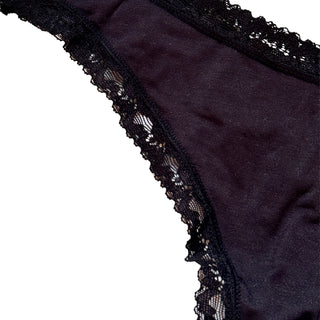 Black lace-trimmed thong underwear on a white background