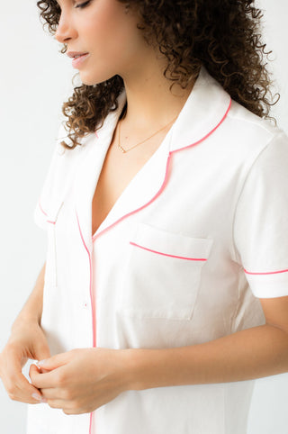 Woman wearing soft pima cotton white pajama top with pink detailing