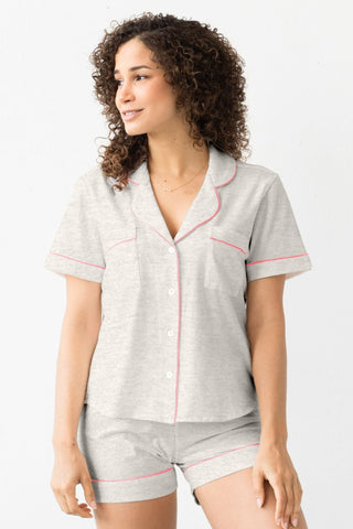 Woman wearing short cotton pajama set in heather grey and neon pink detailing