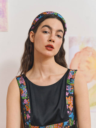 Woman wearing black and colorful floral headband with matching outfit