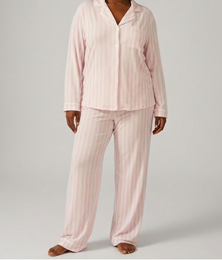 Woman wearing soft pink and white pajama set