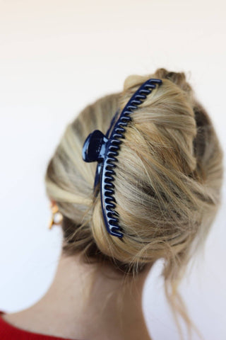 Girl with blonde hair style with a blue claw clip