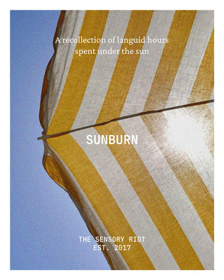 Album cover for 'SUNBURN' by 'THE SENSORY RIOT EST. 2017', featuring a low-angle photograph of a yellow and white striped beach umbrella against a blue sky, with white text overlays.