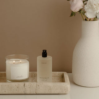 Moonstruck Ritual Spray on a tray next to a candle and flowers