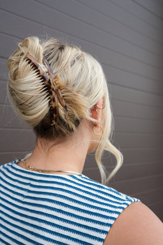 Person with styled blonde hair in a tortoise shell claw clip